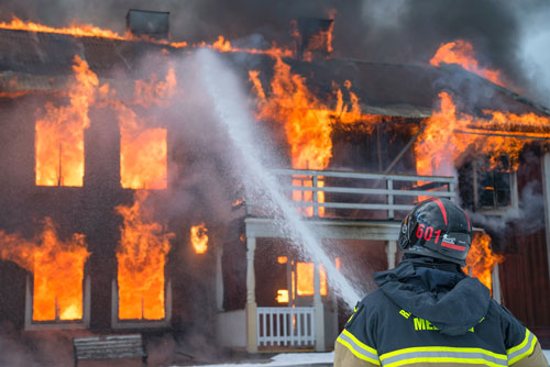 Firefighter in front of burning building